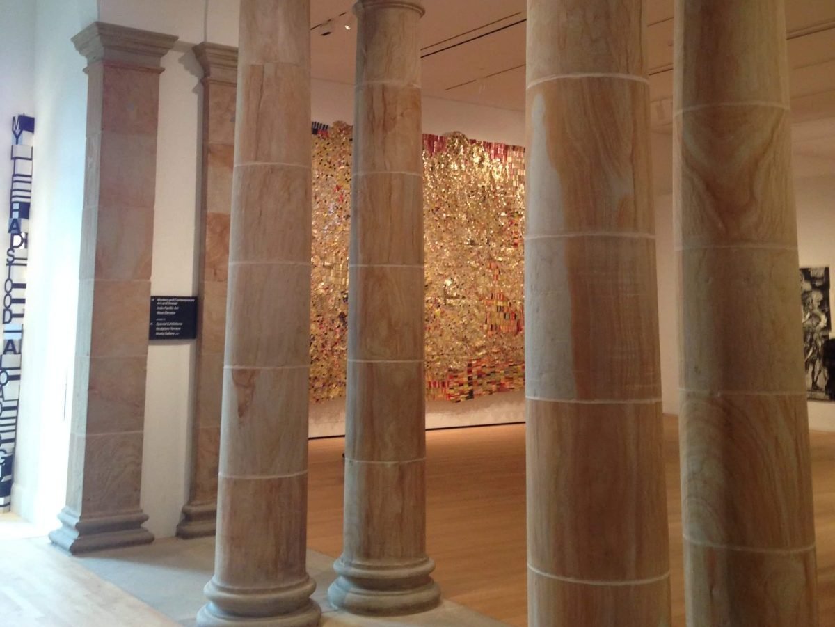 A glittering gold artwork behind columns