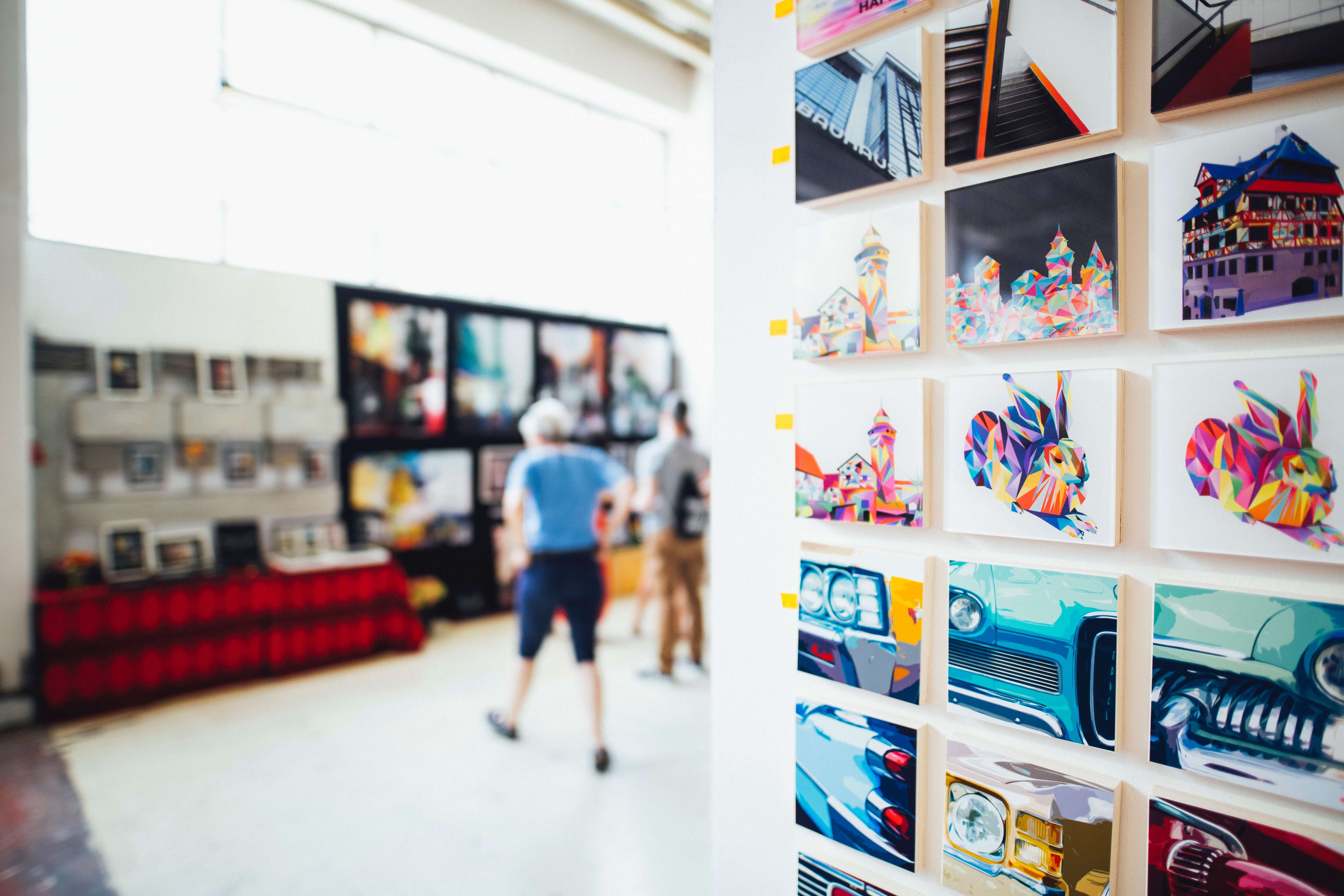 People looking at colorful artwork in an art gallery