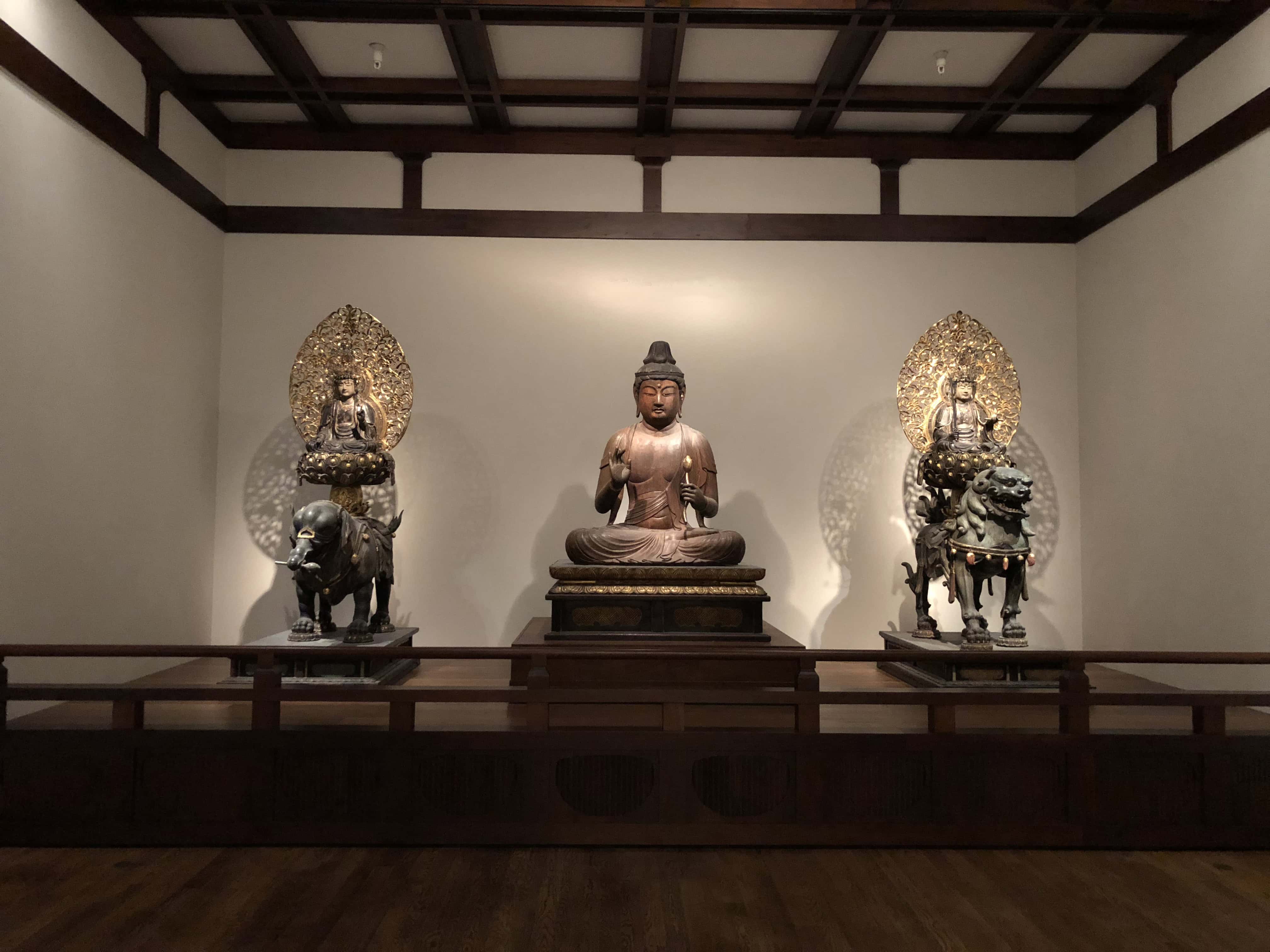 Three southeast Asian statues in a museum gallery