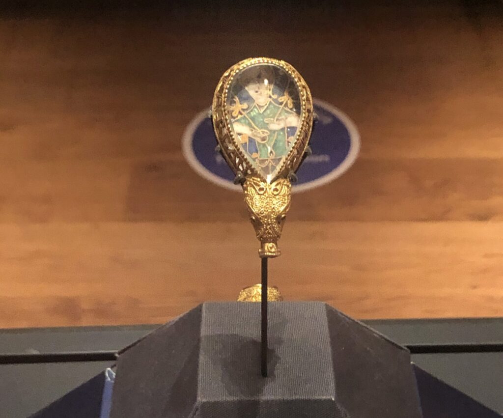 A teardrop-shaped medieval jewel in a glass case