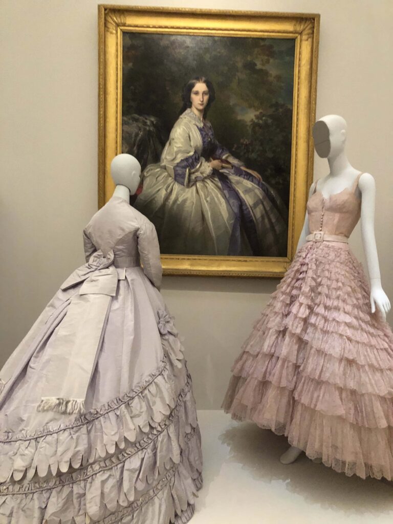 Two dresses beside a painting