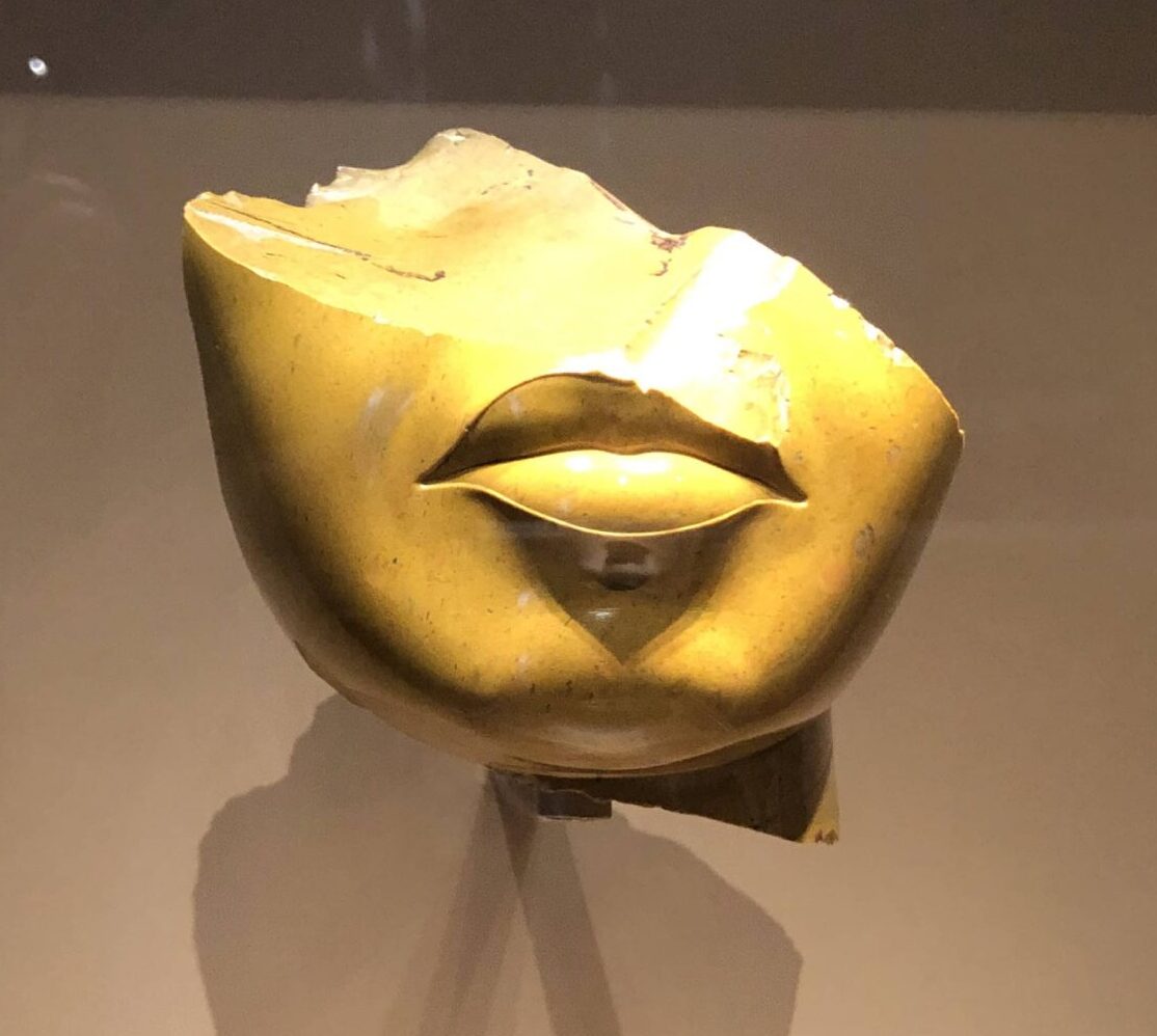 Golden yellow statue of a fragmentary female face