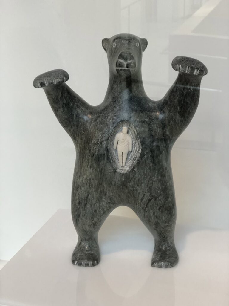 A sculpture of a bear with a tiny person inside